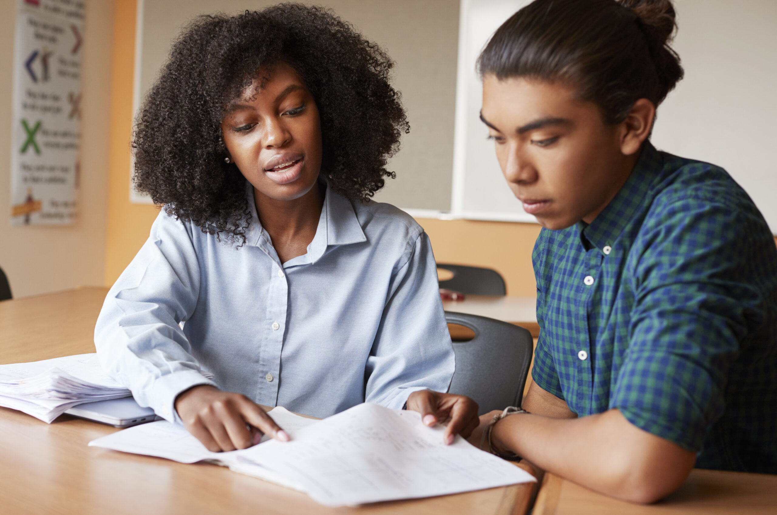 Tutor helping a high school student with schoolwork